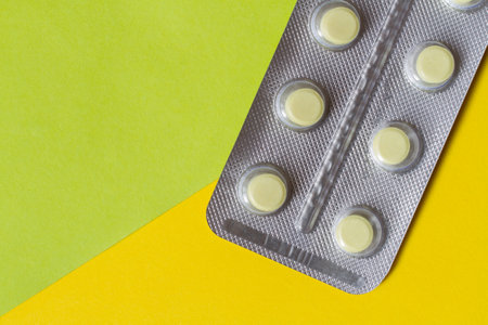 Blister with tablets on a yellow green background. Tablets close-up.の写真素材