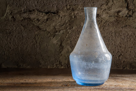 An old bottle made of blue glass. An old dusty bottle on a stone background.の写真素材