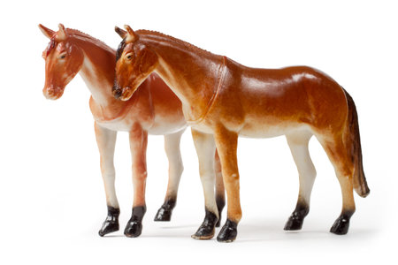 A pair of toy horses on a white background. The figures of horses are isolated on a white background.の写真素材