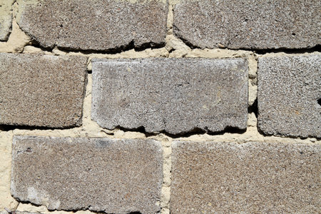The texture of the gray cinder block wall. The granular surface of the cinder block is close-up.