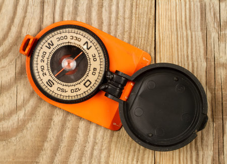 Old compass on a wood background. orange compass close up.の写真素材