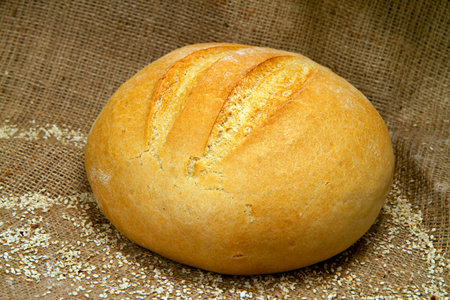 Bread with sesame seeds on burlap background.