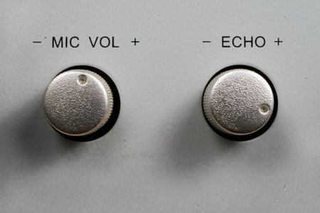 Microphone adjustment handles on the audio device. Round silver handles close-up.