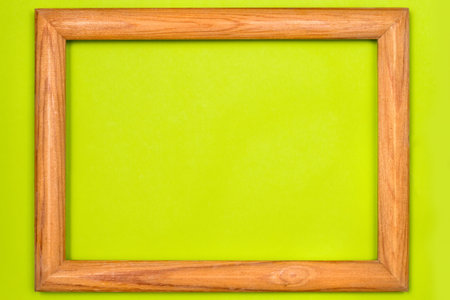 Frame for paintings and photos made of natural wood. Wooden frame on a green background.の写真素材