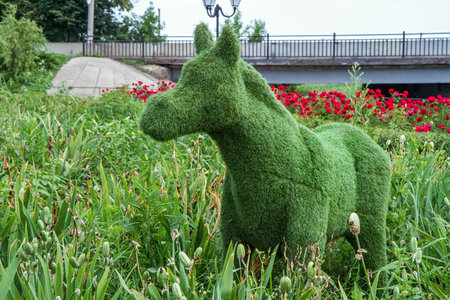 Green moose made of grass in the city park with flowers.の写真素材