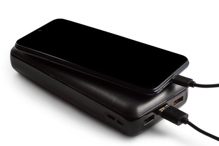 The smartphone is charged from a power bank. Charging modern devices.の写真素材