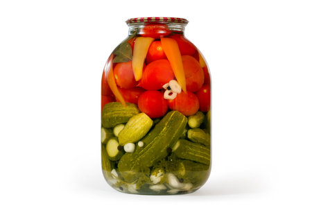 A jar of canned cucumbers and tomatoes. Canned natural vegetables in a glass jar.の写真素材