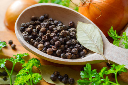 Black peppercorns in a wooden spoon. Spices and seasonings. Selective focus.の写真素材