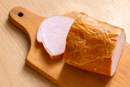 Smoked meat on a wooden cutting board. Sliced meat balyk.
