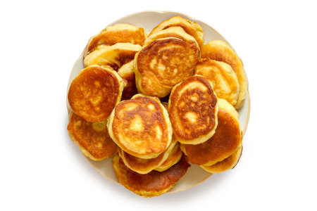 A plate of homemade pancakes on a white background. Top view. Freshly baked homemade cakes.