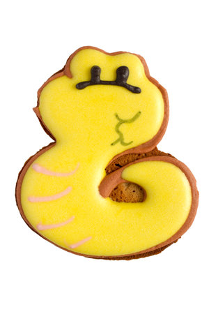 Christmas gingerbread snake close-up on white background. Glazed Christmas cookies.