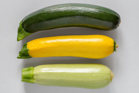 Multicolored zucchini on a gray background. Three different zucchini.の写真素材