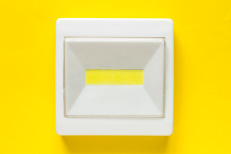 LED light switch on a yellow background. White Plastic Rectangular Lantern
