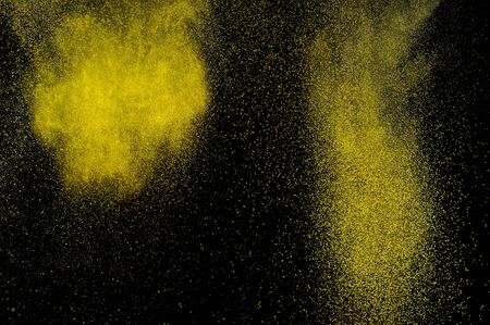 Abstract yellow and gold powder explosion on black background.の写真素材