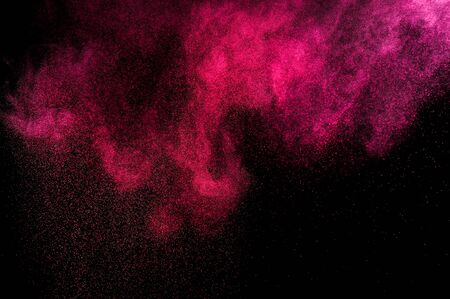 Abstract red and pink powder explosion on black background.の写真素材