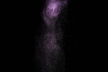 Abstract purple powder explosion on black background.の写真素材