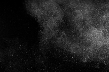 abstract white dust explosion on black backgroundの写真素材