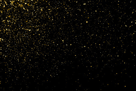 Gold glitter texture on a black background. Holiday background. Golden explosion of confetti. Golden grainy abstract  texture on a black  background. Design element.  のイラスト素材