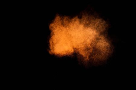Abstract orange powder explosion on black background. Paint  Holi.