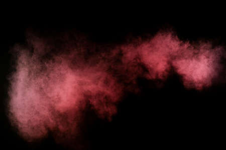 Red and pink powder explosion on black background.の写真素材