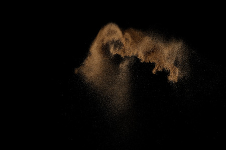 Sandy explosion isolated on black background. Abstract sand cloud.