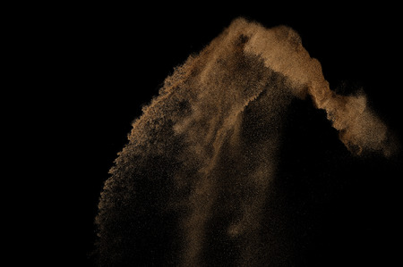 Sandy explosion isolated on black background. Abstract sand cloud.の写真素材