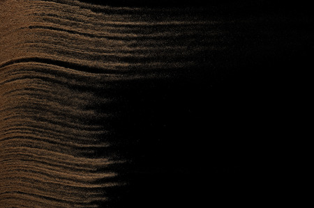 Sandy wave isolated on black background. Abstract sand explosion. Grainy texture.の写真素材