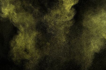 Gold powder explosion on black background. Yellow  cloud. Golden dust explode. Freeze motion paint ...