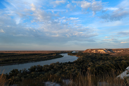 Golden sunset on the river. Autumn landscape. Beautiful clouds and hills.の写真素材