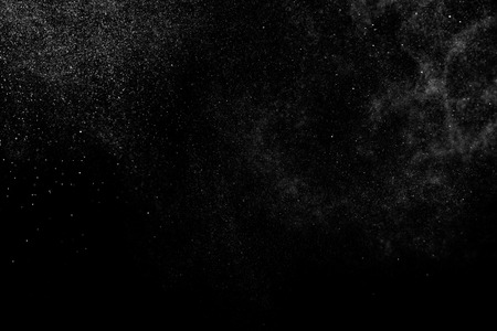 Abstract splashes of water on black background. Freeze motion of white particles. Rain, snow overlay texture.の写真素材