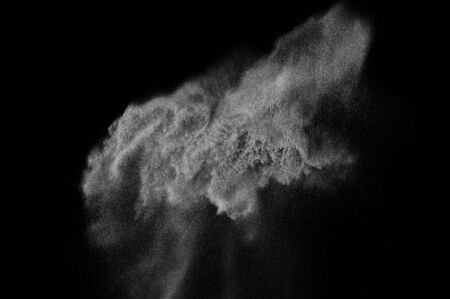 Freeze motion of white particles on black background. Powder explosion. Abstract dust overlay...