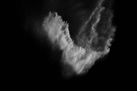 Freeze motion of white particles on black background. Powder explosion. Abstract dust overlay...