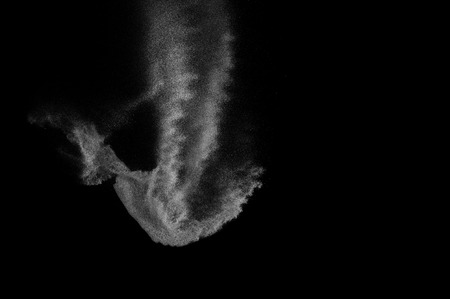 Freeze motion of white particles on black background. Powder explosion. Abstract dust overlay...