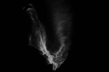 Freeze motion of white particles on black background. Powder explosion. Abstract dust overlay...