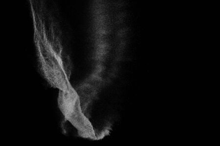 Freeze motion of white particles on black background. Powder explosion. Abstract dust overlay...
