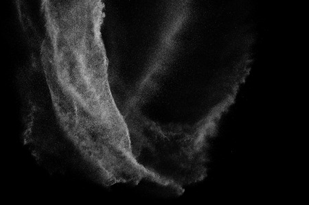 Freeze motion of white particles on black background. Powder explosion. Abstract dust overlay...
