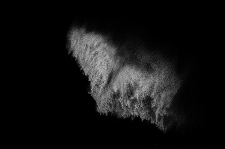 Freeze motion of white particles on black background. Powder explosion. Abstract dust overlay texture.の写真素材