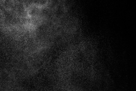 Abstract splashes of water on black background. Freeze motion of white particles. Rain, snow overlay texture.の写真素材