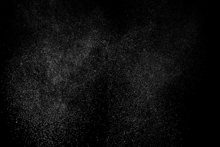 Abstract splashes of water on black background. Freeze motion of white particles. Rain, snow overlay texture.の写真素材