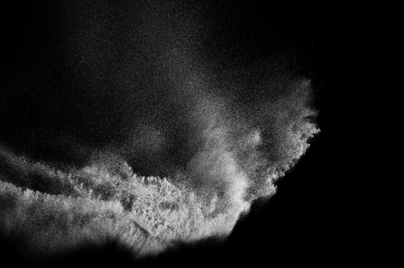 Freeze motion of white particles on black background. Powder explosion. Abstract dust overlay texture.の写真素材
