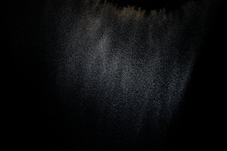 Sandy explosion isolated on black background. Abstract particles cloud. Texture element for design.の写真素材