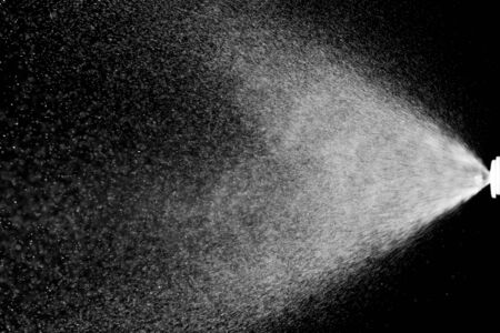 Abstract splashes of water on black background. Freeze motion of white particles. Rain, snow overlay texture.の写真素材