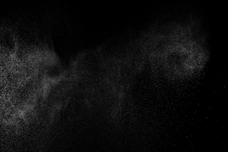 Abstract splashes of water on black background. Freeze motion of white particles. Rain, snow overlay texture.の写真素材