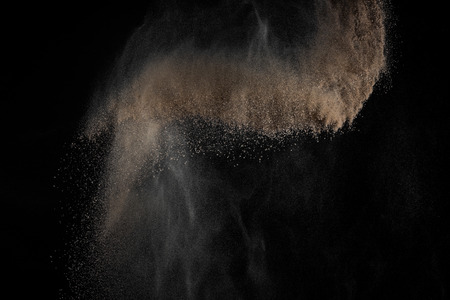 Soil explosion isolated on black background. Abstract cloud of brown ground.の写真素材