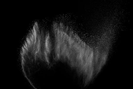 Freeze motion of white particles on black background. Powder explosion. Abstract dust overlay texture.の写真素材