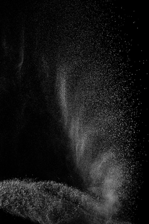 Freeze motion of white particles on black background. Powder explosion. Abstract dust overlay texture.の写真素材