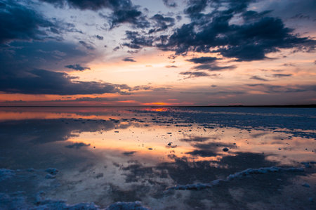 Sunset or sunrise sky. Clouds over water. Golden Dawn. Dramatic coast nature background. Beautiful sea beach at sunset. Morning shoreline sunlight.の写真素材
