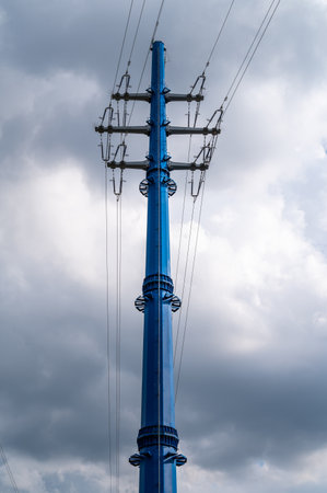 Electricity power pole with transmission lines against blue sky and clouds.の写真素材
