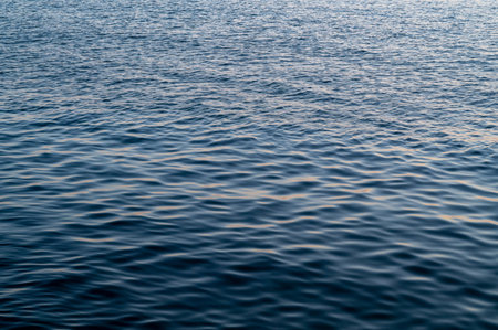 Blue sea surface with waves at sunset, sunrise. Abstract background of water flow in ocean, sea,...