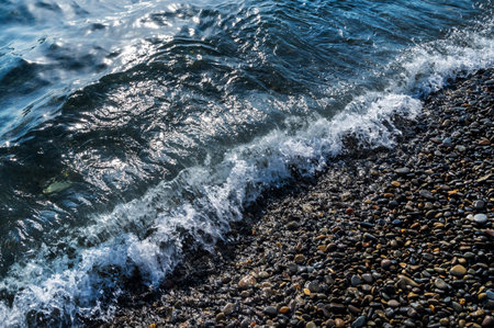 Water sea beach. Wave ocean blue. Stone texture reflection sun. Surface coast pebbles. Abstract light rock background.の写真素材